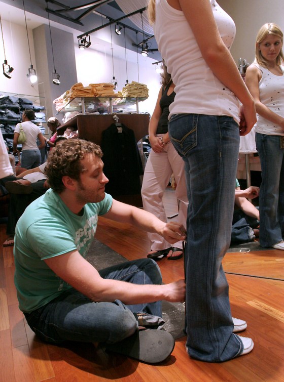 Demin Bar co-owner Mauro Farinelli measures the length of Martine Kostanich's jeans for alteration at the Arlington, Virginia, store, on July 30.