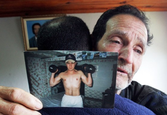 Matuzinho Otone, right, is comforted by an unidentified relative as he holds a picture of his son Jean Charles de Menezes at his home near Gonzaga, Brazil, in this July 24 photo. Menezes, 27, was killed by police at London's Stockwell subway station.