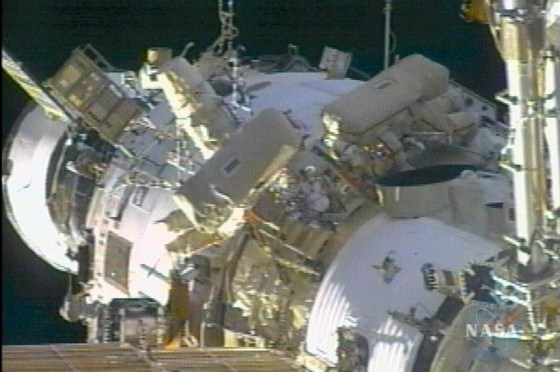Sergei Krikalev and John Phillips work outside the international space station as it orbits Earth on Thursday.