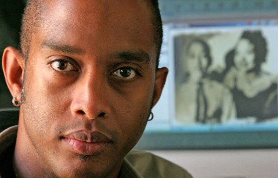 Filmmaker Keith Beauchamp poses in front of a Web site image of Emmett Till and his mother, Mamie Till, on Aug. 17 in New York. Beauchamp made a documentary about the killing of Till. "The Untold Story of Emmett Louis Till" premiered Aug. 15 at the United Nations. It opened two days later in New York and is slated for national distribution.
