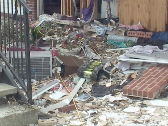 A yellow-green robot with black tracks, equipped with a video camera, climbs down a pile of rubble after inspecting a ruined apartment building in Biloxi, Miss. The robot inspection confirmed there were no survivors inside the unsafe structure.