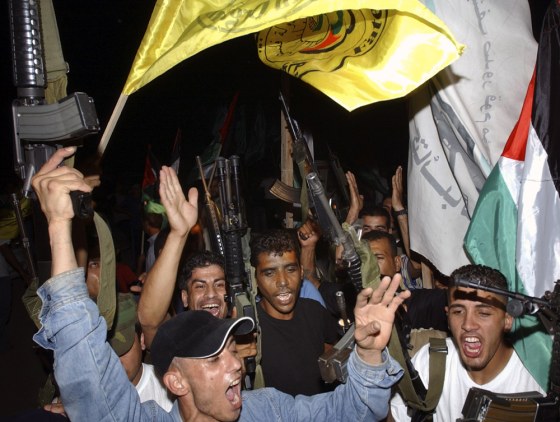 Members of the Palestinian militant group Al Aqsa Martyrs Brigades celebrate after the Israeli army left the northern West Bank Jewish settlement of Qadim on Tuesday.