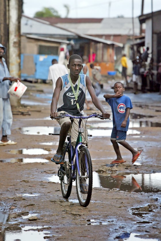 Residents of the slum neighbourhood of Clara Town are seen on a puddle-filled street in the Liberian capital Monrovia