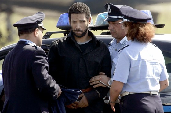 Ethiopian-born Hamdi Issac is escorted by Italian policemen as he arrives at the Ciampino airport in Rome