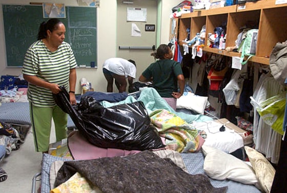 Hurricane Katrina evacuee Savonda Jones, left, sorts clothes Friday at Progressive Baptist Church in Lafayette La.