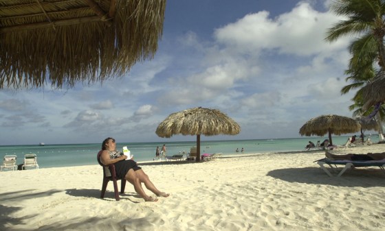 A tourist sleeps on Palm Beach on the northwestern coast of Aruba.