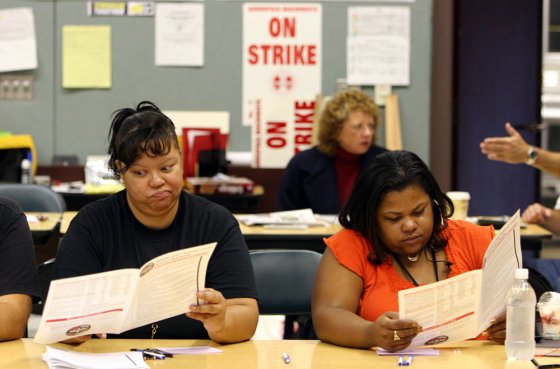 Union stewards Mary Seaton-Gaines, left, a factory service attendant, and Margie Purnell, production lead, read over the summary of the new proposed contract as the striking Boeing workers vote on the proposed contract in Seattle, Wash. on Thursday.