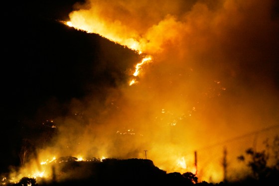 Flames from a wildfire burn near the Chatsworth area of Los Angeles on Wednesday. The blaze hopscotched along the 118 Freeway and threatened homes in the densely wooded Box and Bell canyons.