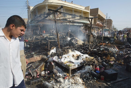 Local residents view destruction after suicide car bomber hits market in Iraqi town of Balad