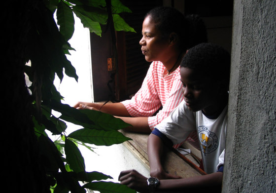 Denise do Espirito Santo and her 13-year-old son, Rajiv, stand in the window of their home in Rocinha, the largest poor urban neighborhood in Rio de Janeiro.