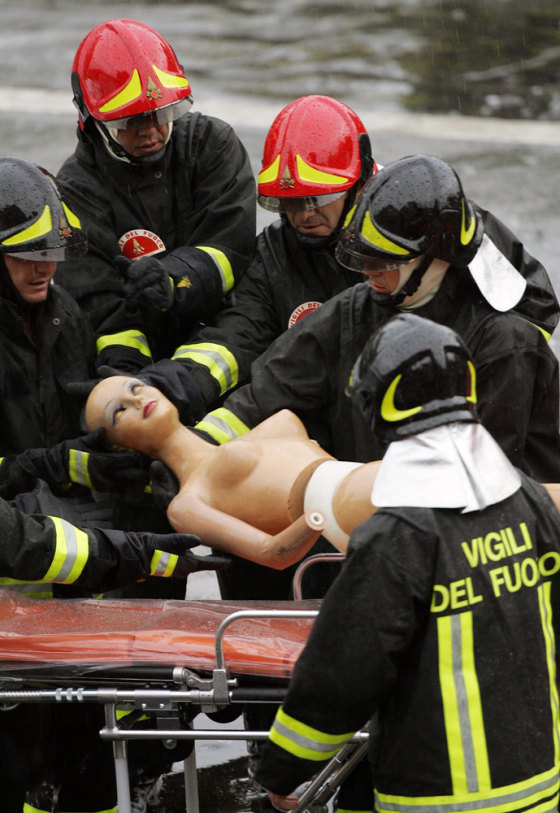 Italian firemen evacuate a puppet used a