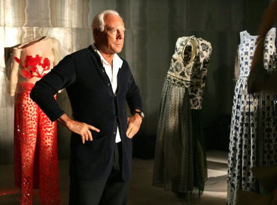 Italian designer Giorgio Armani stands next to his creations in Tokyo