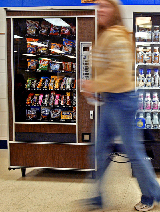 A student walks by a vending machine at Delavan-Darien High School in Delavan, Wis. For many Americans, the vending machine is as much a part of their daily diet as fast food restaurants.