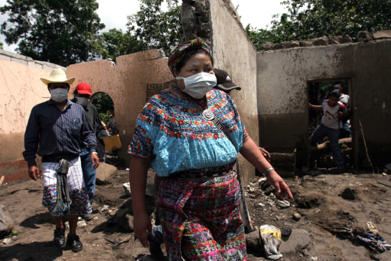 Nobel Peace Prize laureate Rigoberta Menchu walks through a mudslide in Panabaj, Guatemala, on Tuesday. President Oscar Berger, who accompanied Menchu on the inspection tour, said that more than 400 people had been killed by the mudslides in Panabaja alone.