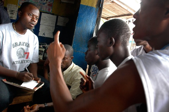 Liberian men react to election results over radio day after their presidential vote in Monrovia