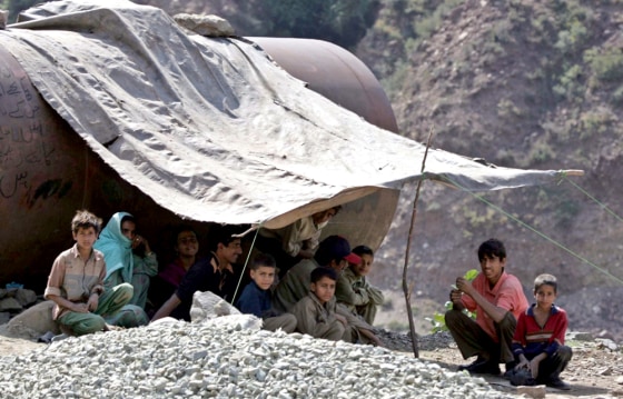 Homeless Kashmiri earthquake survivors sit under sheet in Sultandaki