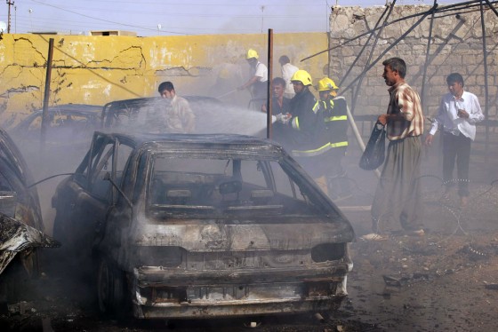 Iraqi firemen douse fire from a burning
