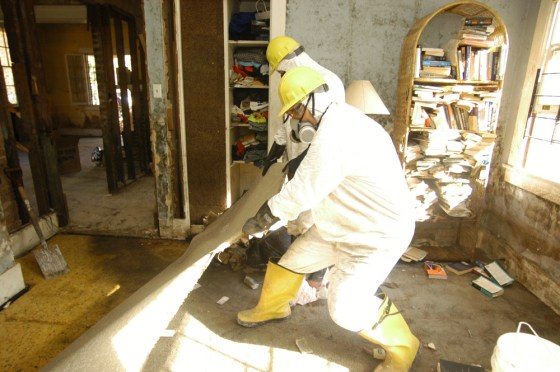 A demolition crew rips out the carpet in Sheila Gregory's home in New Orleans on Oct. 11.