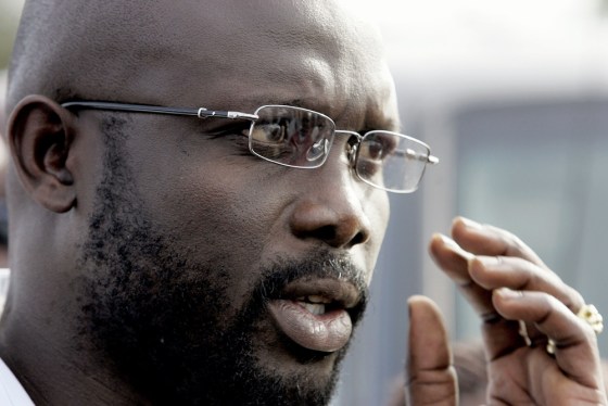 Ex-football star George Weah (C) raises