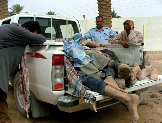 Iraqi factory workers lean against a pickup truck loaded with the bodies of their colleagues killed by suspected insurgents in Iskandariyah, Iraq, on Wednesday.