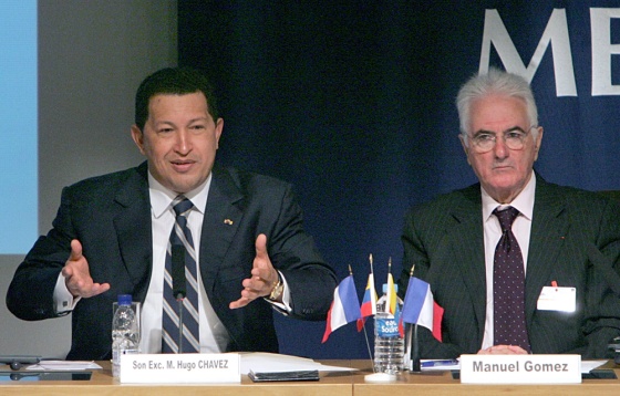 Venezuelan President Hugo Chavez, left, addresses businessmen at France's main employers’ organization, in Paris, on Thursday. He is seated next to Manuel Gomez, a representative of the organization. While in France, he told the BBC that the U.S. is planning to invade his country.
