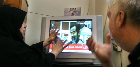 Adnan Fadil al-Saadi, right, who said his brother was executed in 1982 for being a member of an opposition party, and his wife Eman, left, react with anger while watching Saddam Hussein's trial on television in Baghdad on Wednesday.