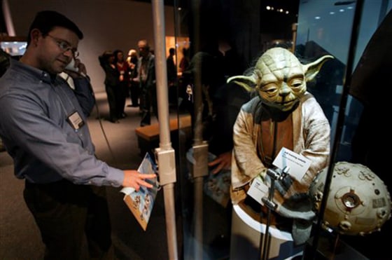 Richard Greif, of Wakefield, Mass., listens to recorded information in front of a "Yoda" puppet at the "Star Wars: Where Science Meets Imagination" exhibit at the Museum of Science in Boston.