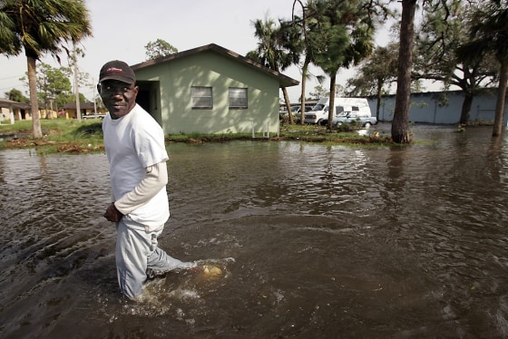 Frantz Grache wades through the waters of his flooded labor housing compound in Immokalee, Fla. after Hurricane Wilma passed over. The hurricane knocked out some key crops in the state, and will mean higher costs for consumers.