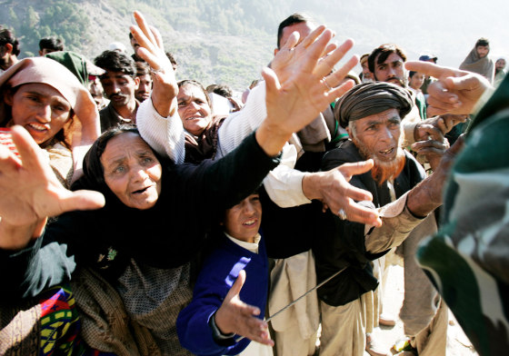 PAKISTANI EARTHQUAKE SURVIVORS REACH FOR RELIEF GOODS