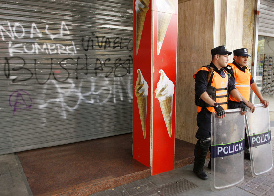 Police stand outside boarded up fast food restaurant in Mar del Plata ahead of Summit of the Americas
