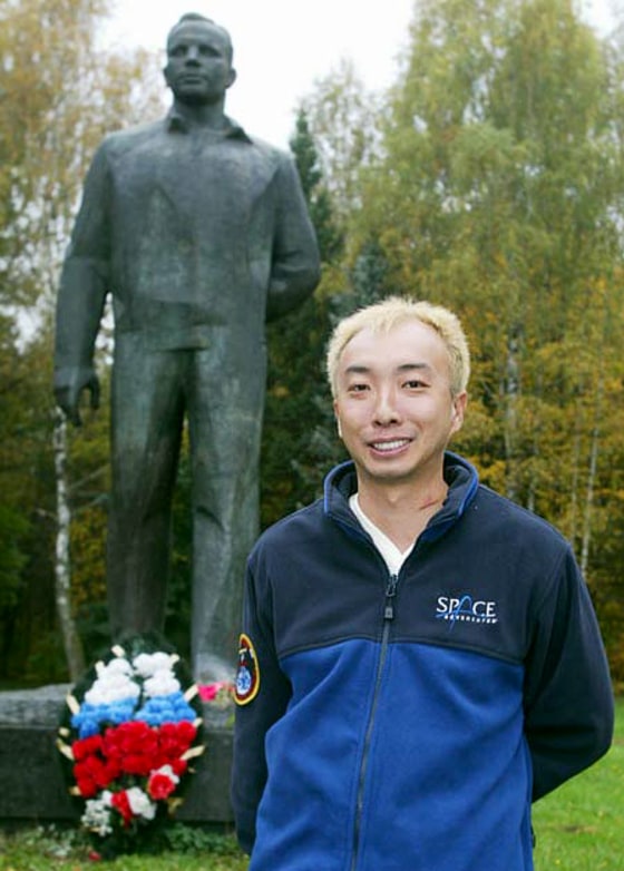 Space passenger-to-be Daisuke "Dice-K" Enomoto flashes a grin during a visit to Russia, with a statue of Soviet spaceman Yuri Gagarin in the background.