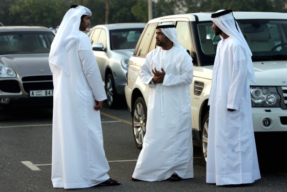 Three men talk in front of the latest models of 4x4s in Dubai, United Arab Emirates, on Nov. 7.