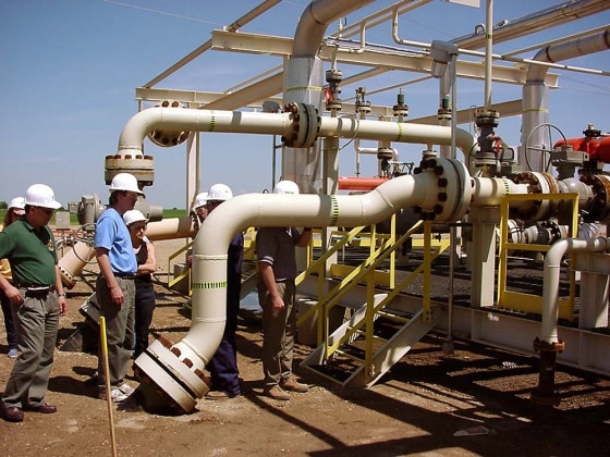Carbon dioxide from an industrial plant in North Dakota enters a Canadian oil field via the gray pipe in this photo.