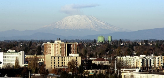 Rockfall kicks up a dust plume that rises above the rim of Mount St. Helens' volcanic crater on Tuesday, providing the background for this view from Portland, Ore.