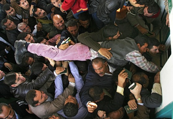 A Palestinian jumps over other people to