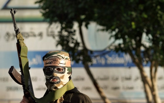 A masked gunman looks on Monday after armed militants closed a polling station during the Fatah movement primaries in Khan Younis, in the southern Gaza Strip.