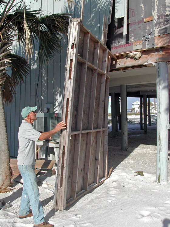 Gene Hudkins works to repair his beach house at Navarre Beach on Santa Rosa Island, Fla., in November. The bottom floor, where he had his workshop, has been wrecked three times since he built the house in 1994.