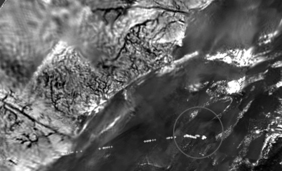 A mosaic of imagery from the Huygens probe's descent camera shows riverbeds that may have been cut by liquid methane. The dotted line and circle toward the bottom of the image trace the path of Huygens' descent to the surface.
