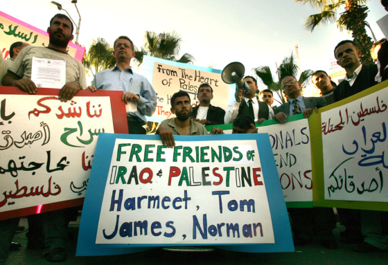Palestinians hold banners during a demonstration n the West Bank town of Ramallah on Thursday, calling for the release of four foreigners kidnapped in Iraq.
