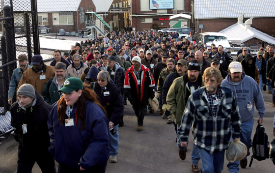 Workers pour out of the main gate at the Electric Boat in Groton, Conn., Tuesday. Electric Boat plans to eliminate up to 2,400 jobs by the end of next year.