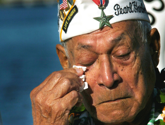 Herb Weatherwax cries during a sunrise ceremony in front of the Arizona Memorial in Pearl Harbor