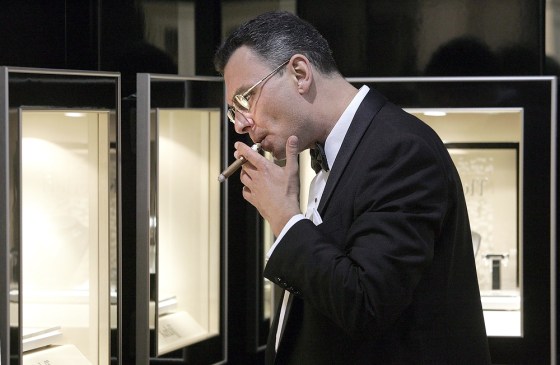 A man smokes a cigar as he looks at the