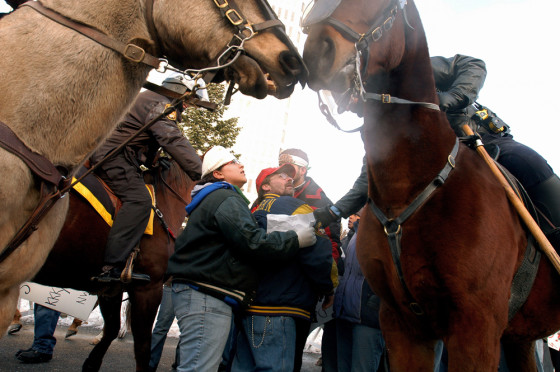A protester, center in red hat, is arrested during a National Socialist Movement rally on Saturday in Toledo, Ohio.