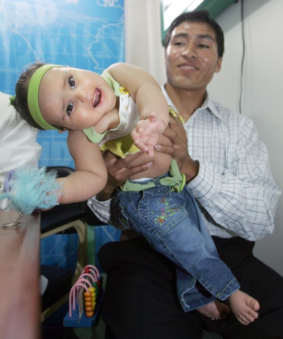 Milagros Cerron plays with her father, Ricardo Cerron, during a news conference in a municipal hospital in Lima, Peru on Tuesday.