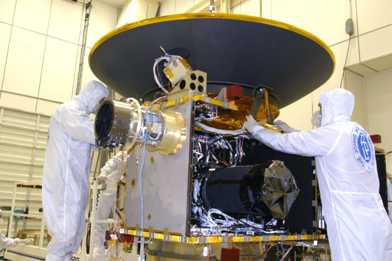 Team members at the Johns Hopkins University Applied Physics Laboratory attach New Horizons' high-gain antenna assembly during processing in April 2005. The spacecraft is carrying a compact disc with 435,000 digitized names recorded on it.