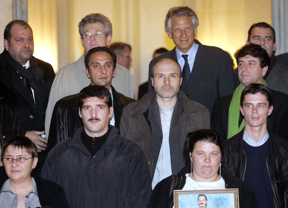 French Prime Minister Dominique de Villepin, second right at top, poses with some of the people acquitted of pedophilia charges in Paris last December.