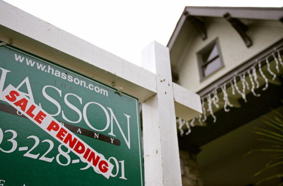 A realtor's sign hangs in front of a house for sale in Portland