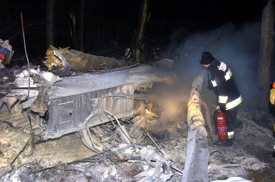 A firefighter examines wreckage on the scene of the plane crash near the village of Hejce, northeast of Budapest, late Thursday.