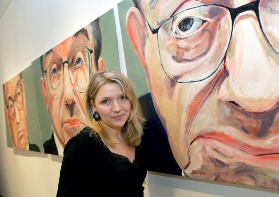 Artist Crowe poses with her paintings at \"Good-bye...Greenspan\" art exhibition in New York