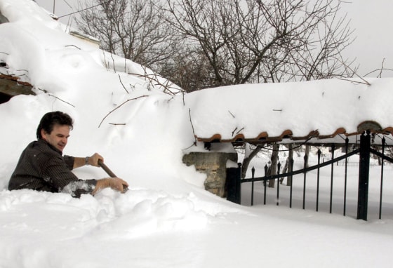 A man digs a path in the snow to reach t
